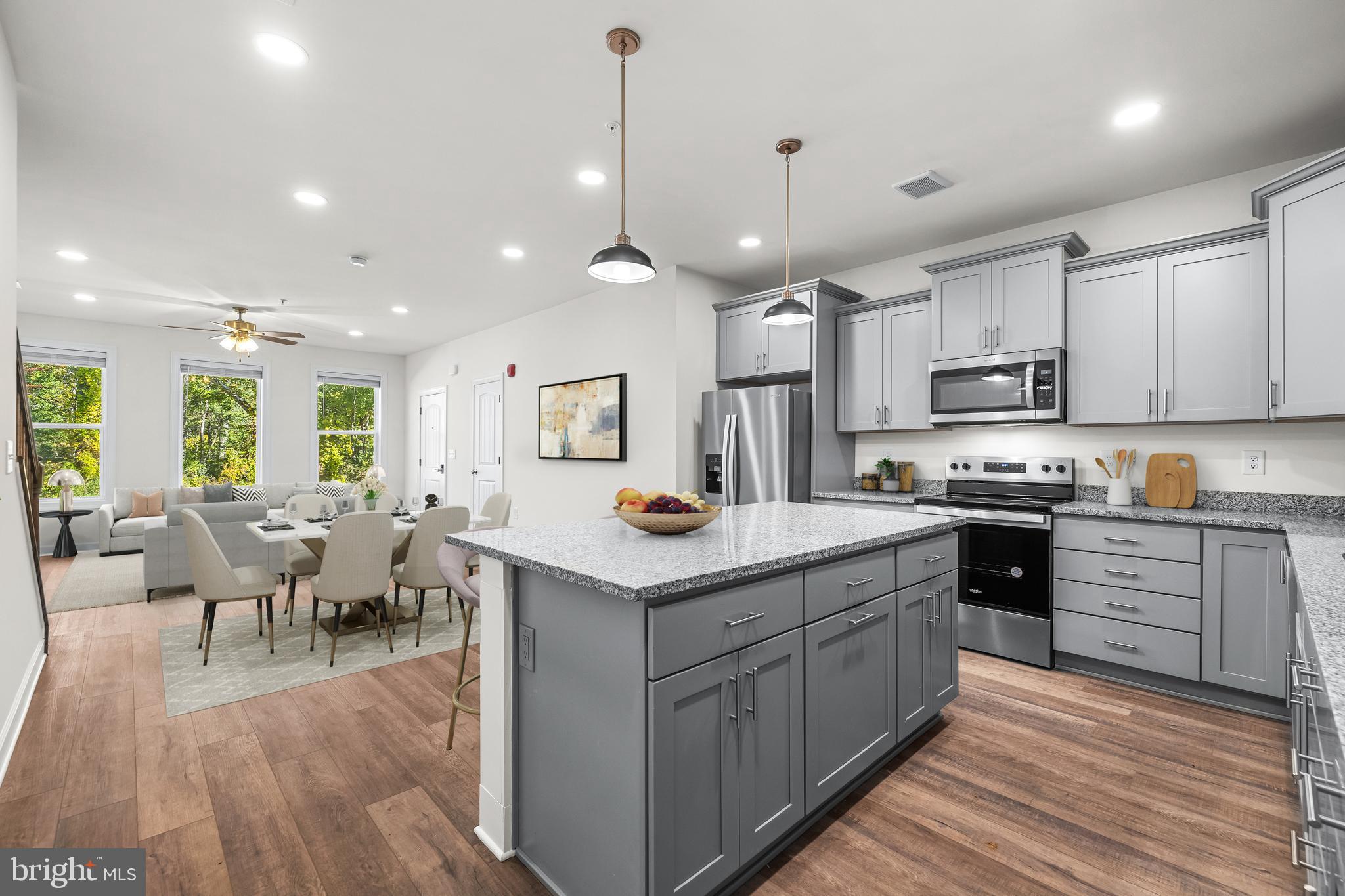 900 Gilbert Road, Unit 3614B Aberdeen, MD 21001 - Photo 7 of 22 a kitchen with stainless steel appliances kitchen island granite countertop a stove top oven a sink a dining table and chairs with wooden floor