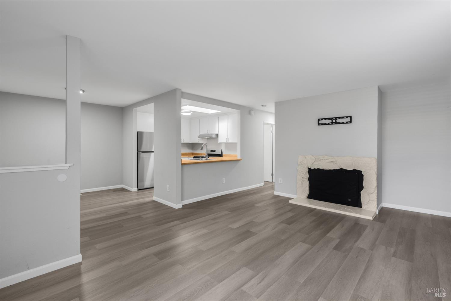 735 Blair Place Santa Rosa, CA 95401 - Photo 10 of 16 a view of empty room with wooden floor and kitchen