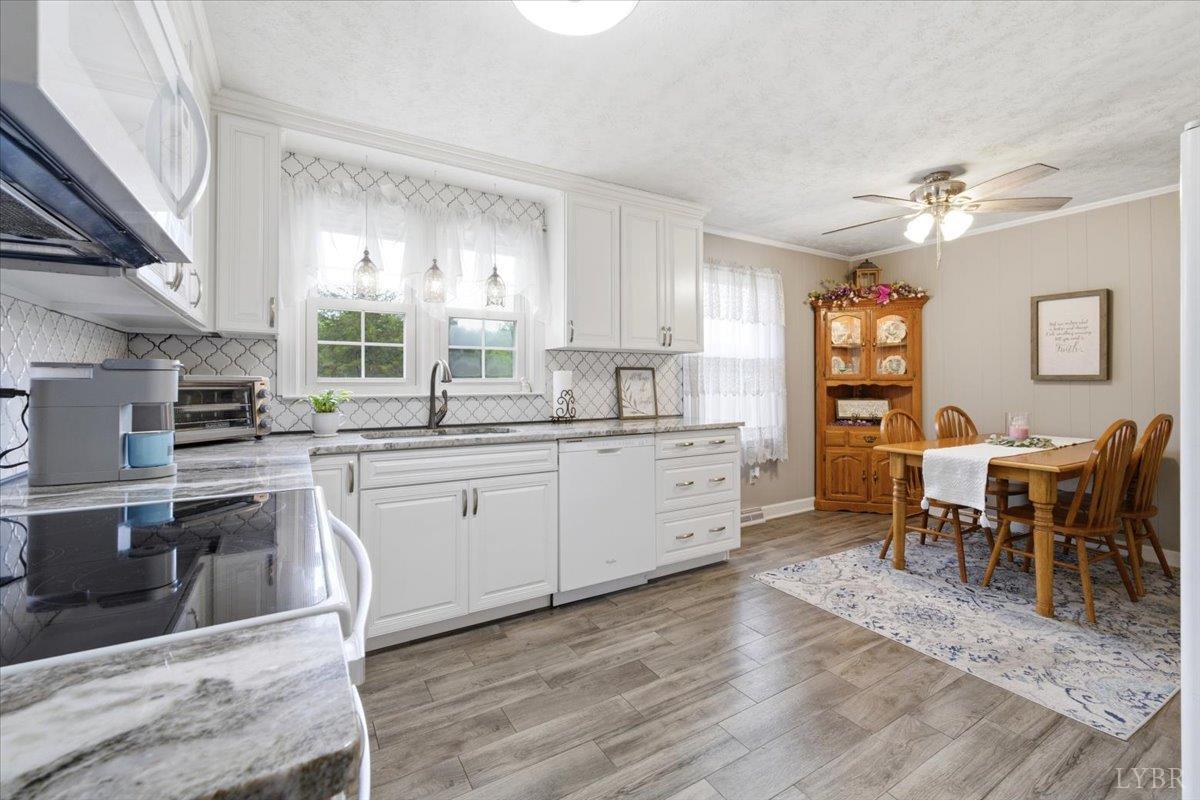 6141 Renan Road Hurt, VA 24563 - Photo 10 of 34 a kitchen with stainless steel appliances sink dining table and chairs