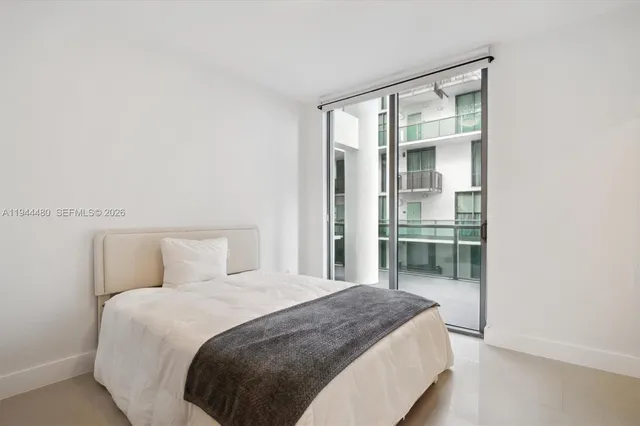 a bed sitting in a bedroom next to a window