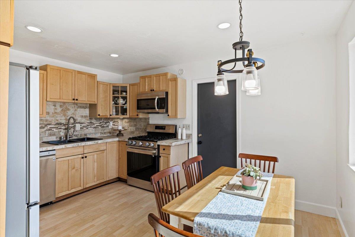 10402 Newtown Road Nevada City, CA 95959 - Photo 12 of 44 a kitchen with stainless steel appliances kitchen island granite countertop a refrigerator a stove top oven a sink dishwasher and a dining table with wooden floor