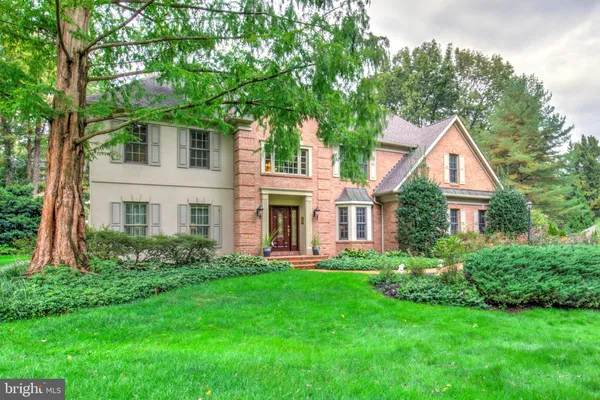 a front view of a house with a yard and trees