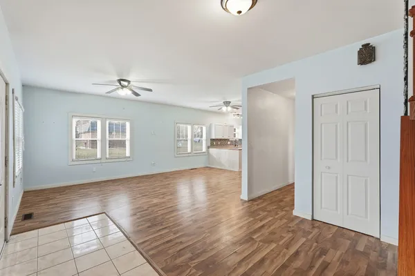 a view of an empty room with window and wooden floor
