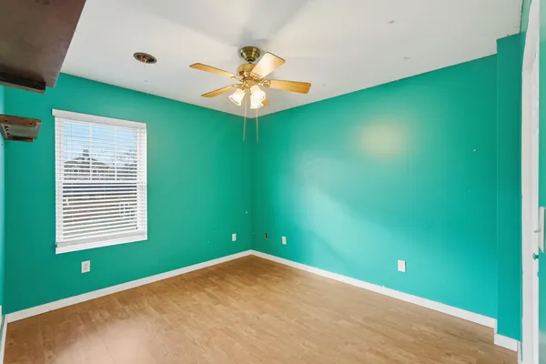 a view of an empty room with window and fan