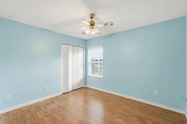 an empty room with a window and a fan