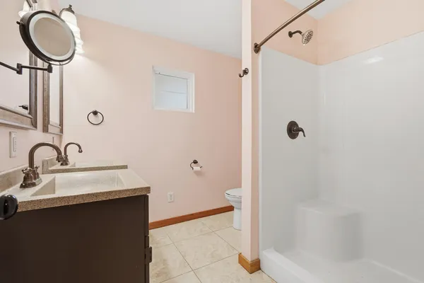 a bathroom with a sink a toilet and shower