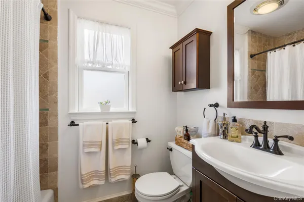 a bathroom with a sink vanity mirror and toilet