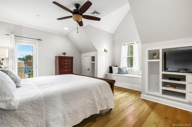 a spacious bedroom with a bed and a flat screen tv