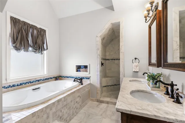 a spacious bathroom with a granite countertop tub sink and mirror