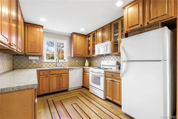 a kitchen with stainless steel appliances granite countertop a refrigerator a sink dishwasher a stove with wooden cabinets and floor