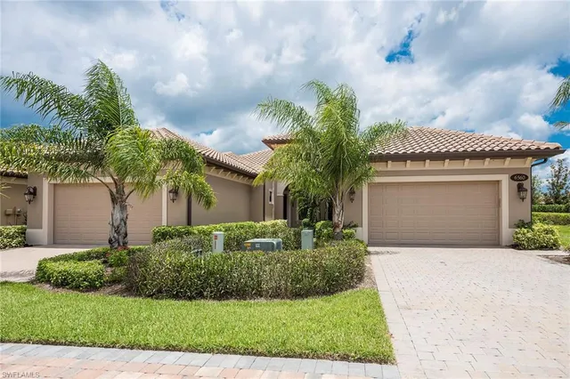 a front view of a house with a garden and palm trees
