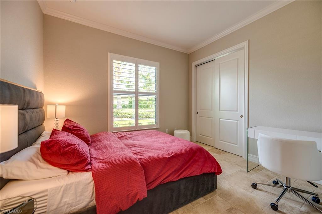 6560 Roma Way Naples, FL 34113 - Photo 14 of 24 a bedroom with a bed a dresser and chair
