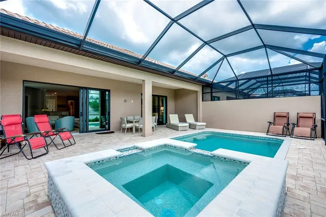 a view of a house with swimming pool and sitting area