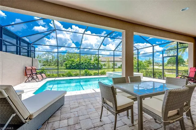 a living room with patio furniture and a potted plant