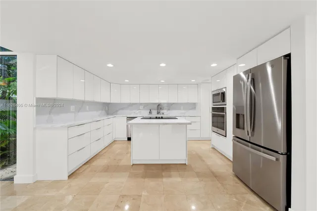 a kitchen with granite countertop a sink and a stove top oven with white cabinets