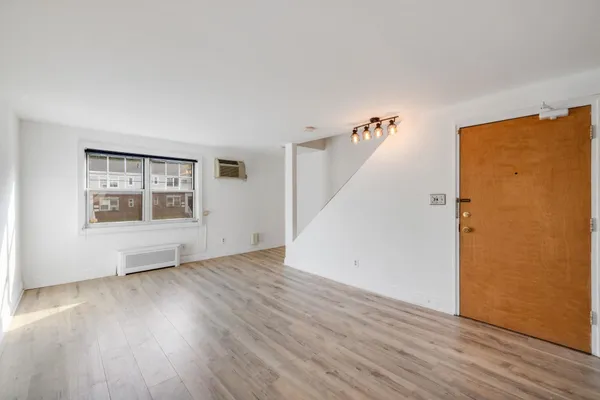 an empty room with wooden floor and windows