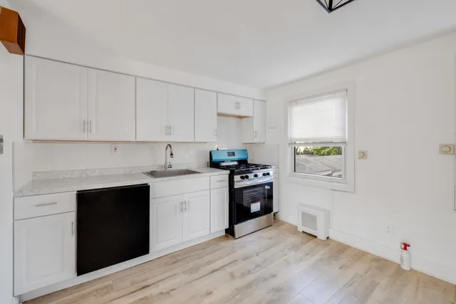 a kitchen with granite countertop a stove top oven and sink