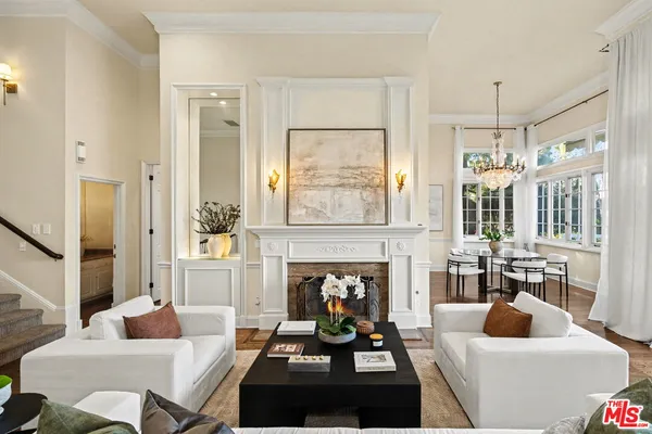 a living room with furniture fireplace and a large window