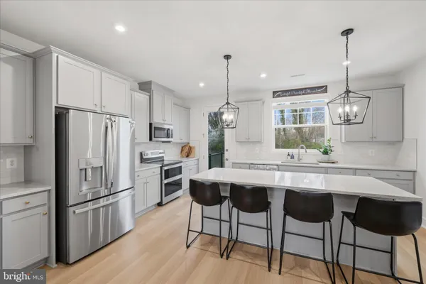 a kitchen with a refrigerator a stove and white cabinets