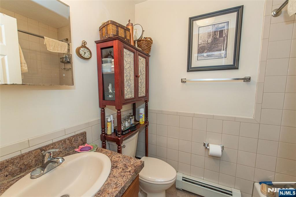 233 9th Street Fairview, NJ 07022 - Photo 5 of 7 a bathroom with a toilet sink and mirror