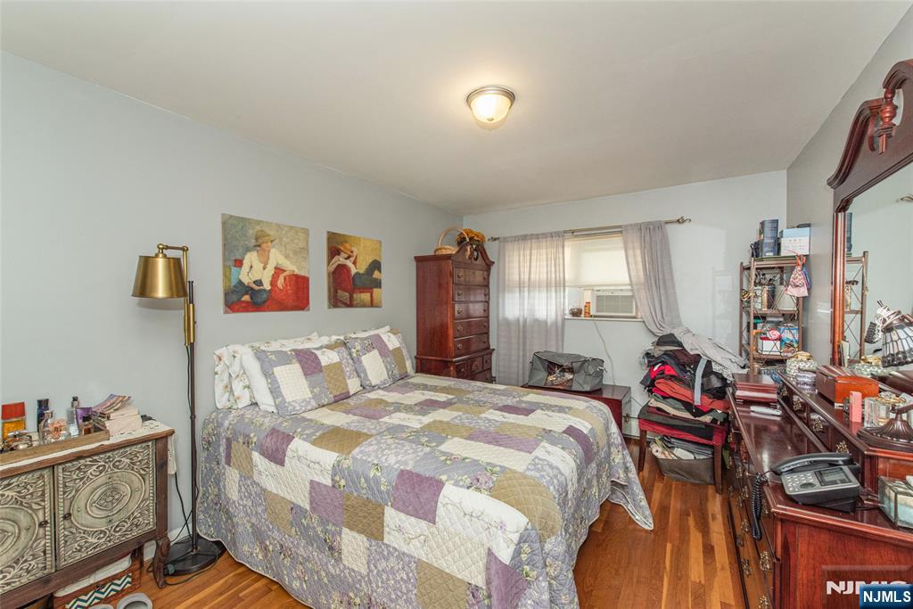 233 9th Street Fairview, NJ 07022 - Photo 6 of 7 a bedroom with a bed and wooden floor