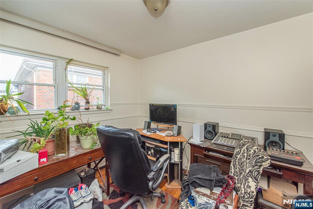 233 9th Street Fairview, NJ 07022 - Photo 7 of 7 a workspace with furniture and a potted plant