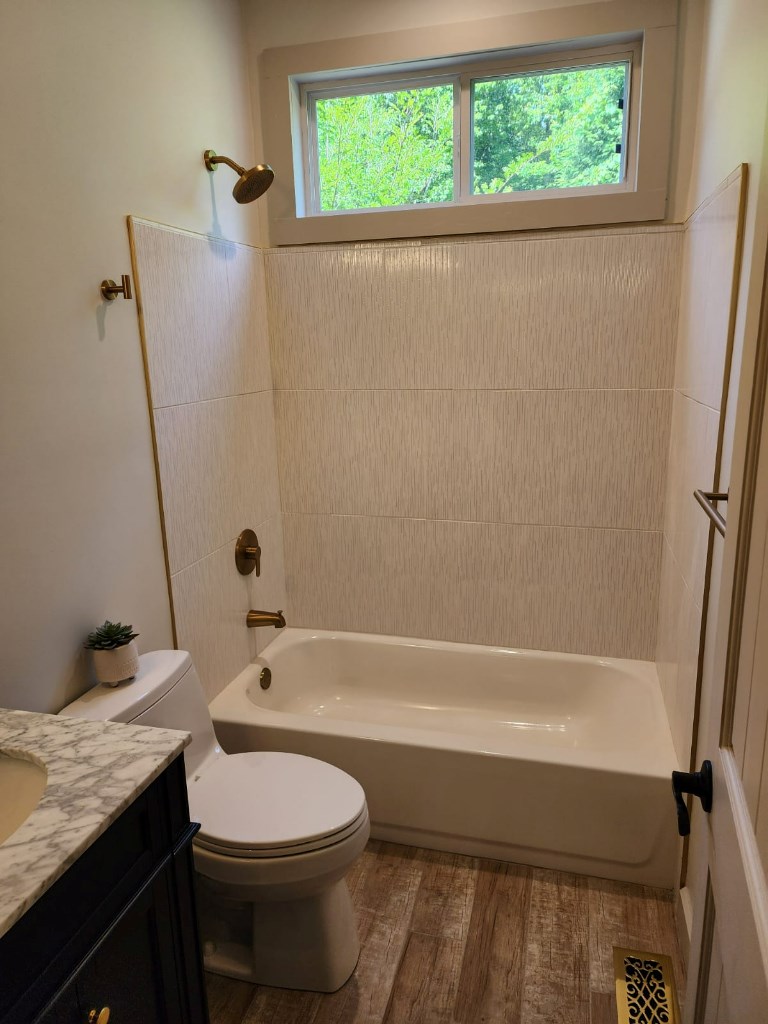 411 Delta Way Blue Ridge, GA 30513 - Photo 17 of 35 a bathroom with a granite countertop toilet a sink and a bathtub
