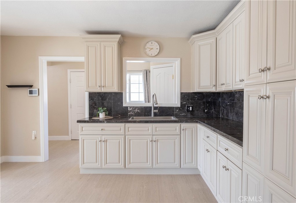 11711 Carmine Street Riverside, CA 92505 - Photo 17 of 33 a kitchen with white cabinets and sink