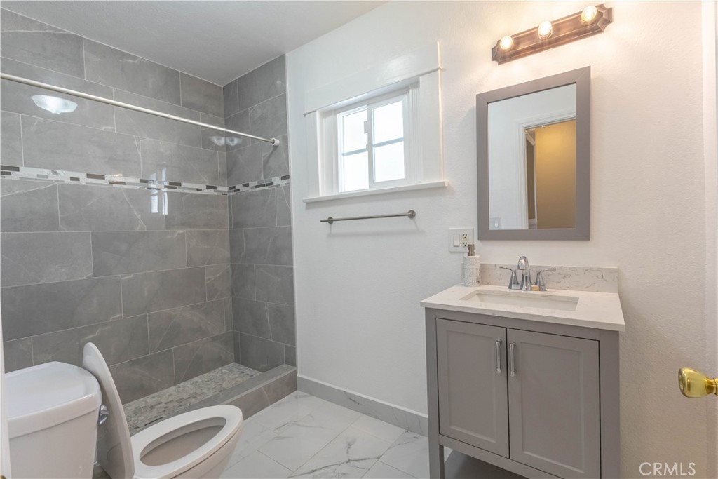 11711 Carmine Street Riverside, CA 92505 - Photo 18 of 33 a bathroom with a sink a toilet and shower