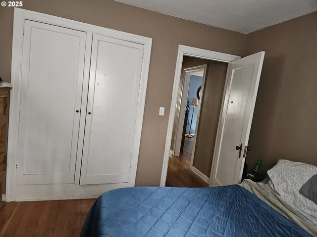 a view of hallway with wooden floor and closet