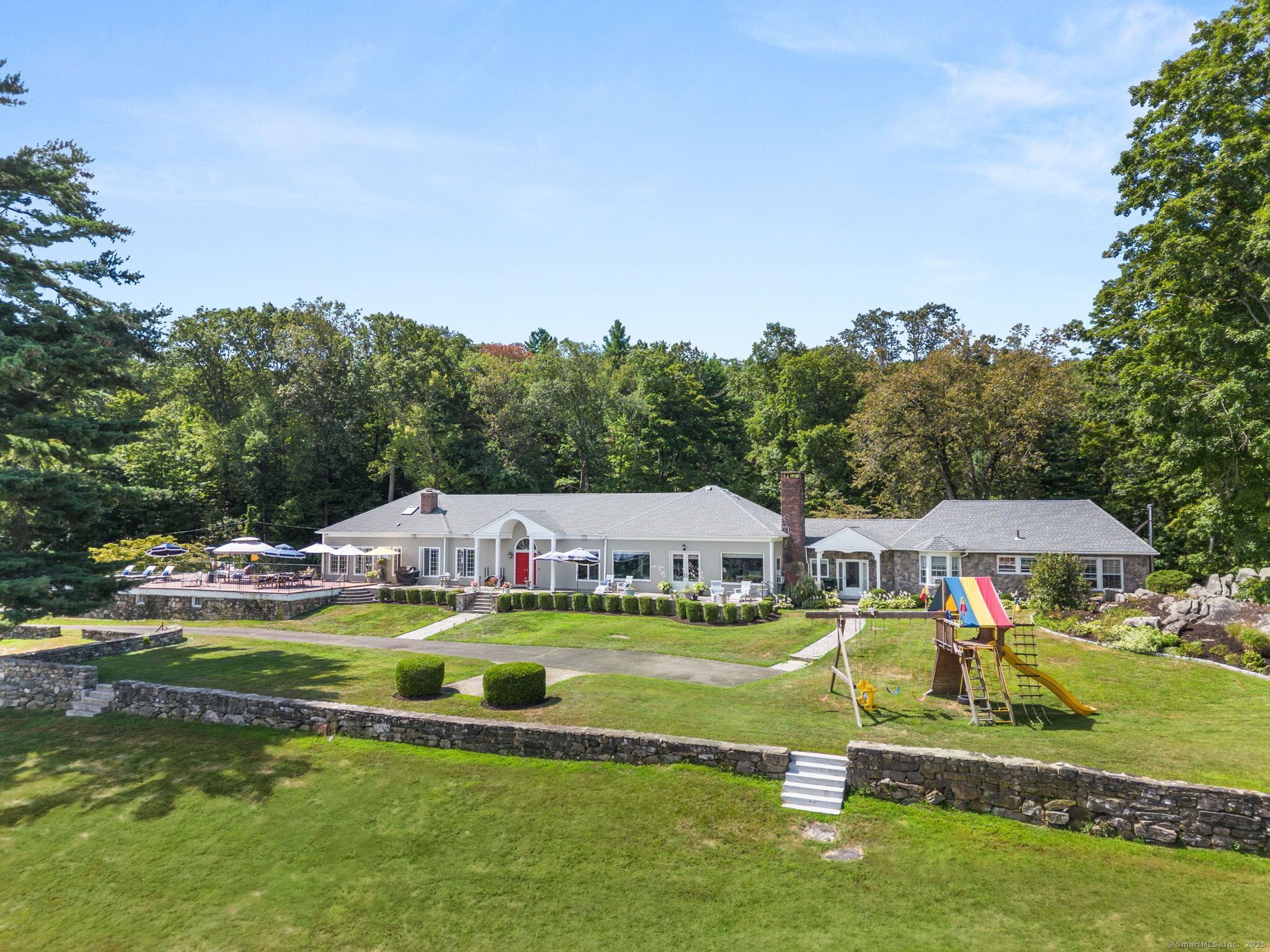 803 North Salem Road Ridgefield, CT 06877 - Photo 3 of 40 a view of a swimming pool with lawn chairs and large trees