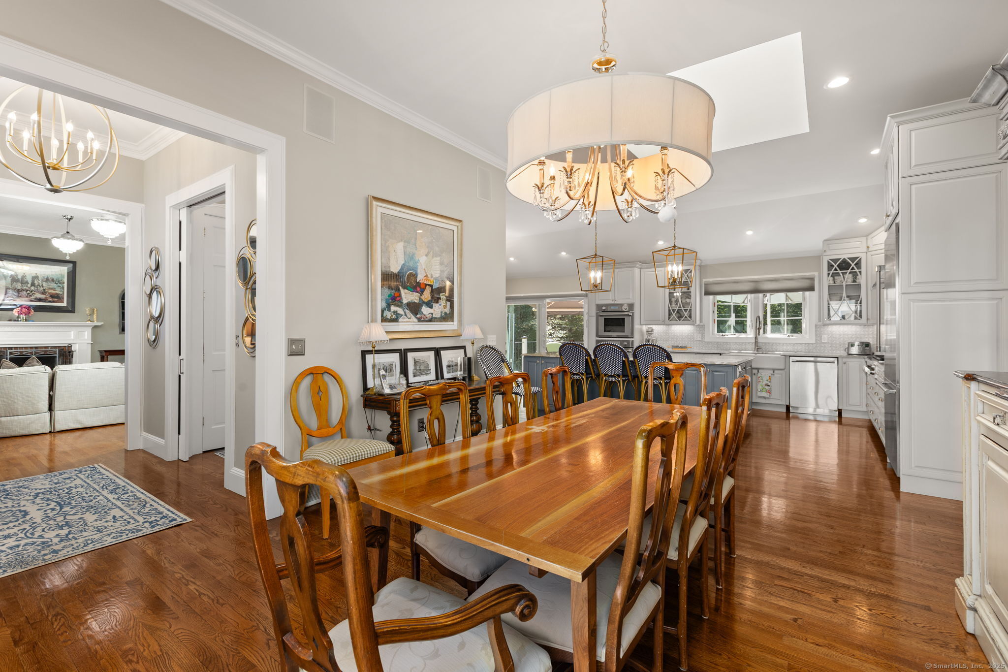 803 North Salem Road Ridgefield, CT 06877 - Photo 9 of 40 a dining room with wooden floor a chandelier a wooden table and chairs