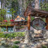 a view of house with wooden deck and outdoor seating