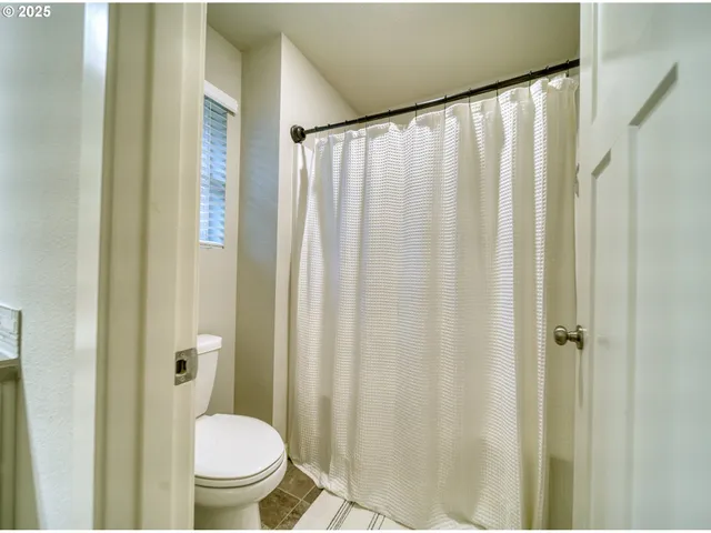 a bathroom with a shower curtain and a toilet