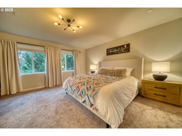 a bedroom with a large bed and a chandelier