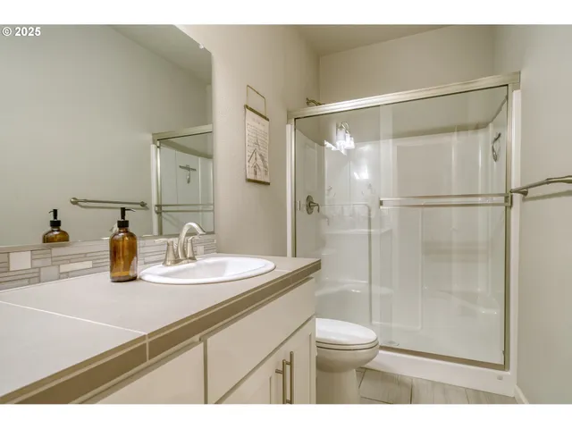 a bathroom with a sink toilet a mirror and shower