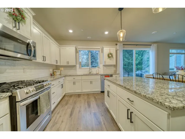 a kitchen with stainless steel appliances granite countertop a stove sink and cabinets