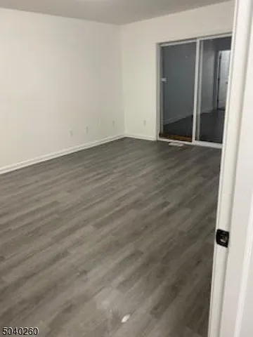 an empty room with wooden floor and mirror