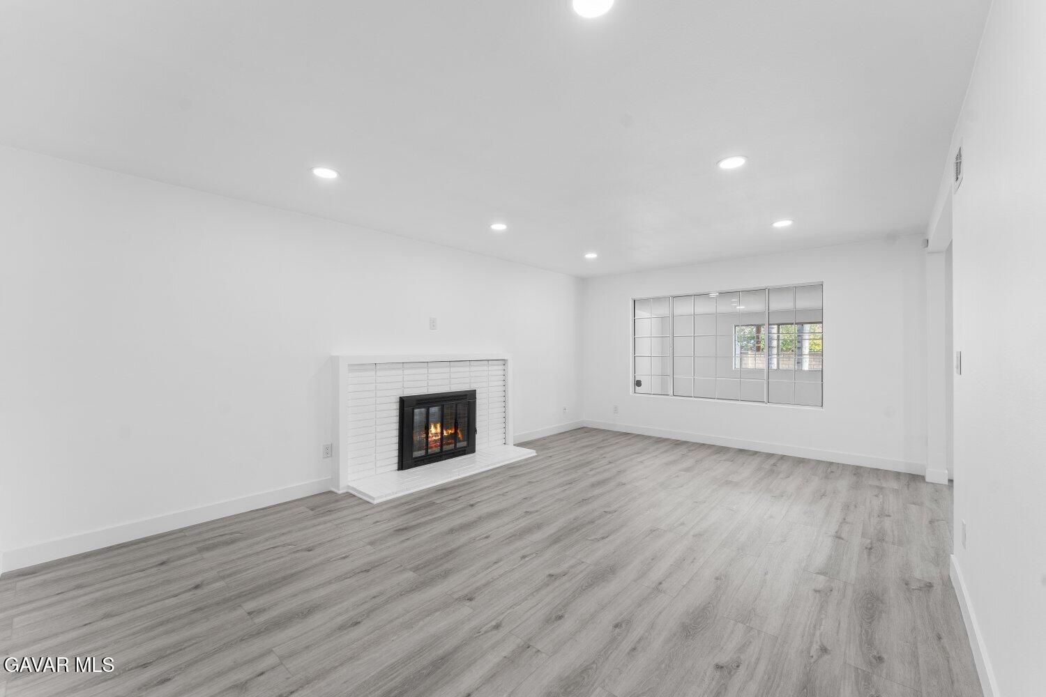 12338 Sheldon Street Sun Valley, CA 91352 - Photo 5 of 60 an empty room with wooden floor fireplace and windows