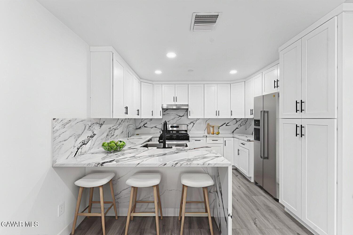 12338 Sheldon Street Sun Valley, CA 91352 - Photo 54 of 60 a kitchen with stainless steel appliances kitchen island granite countertop a table chairs and a refrigerator