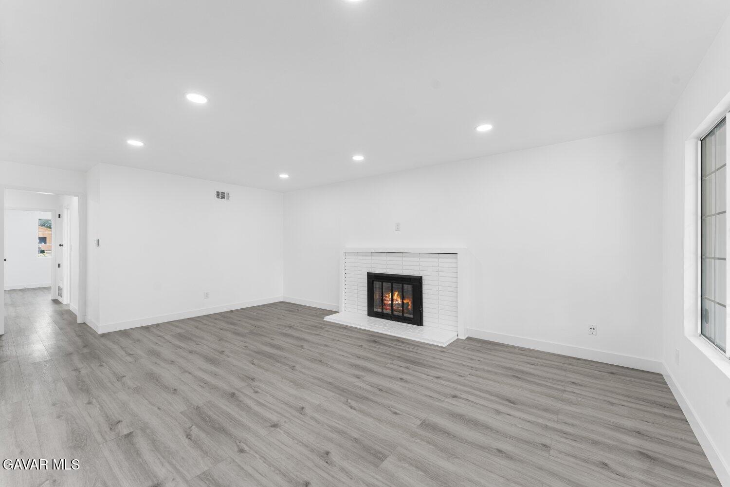 12338 Sheldon Street Sun Valley, CA 91352 - Photo 8 of 60 a view of empty room with wooden floor and fireplace