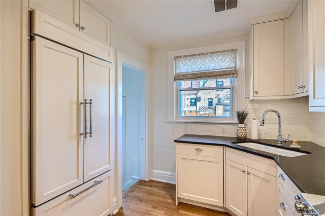 a kitchen with stainless steel appliances white cabinets and a window