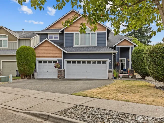 a view of a house with a yard and large tree
