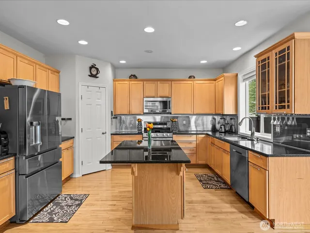 a kitchen with granite countertop a stove top oven and refrigerator
