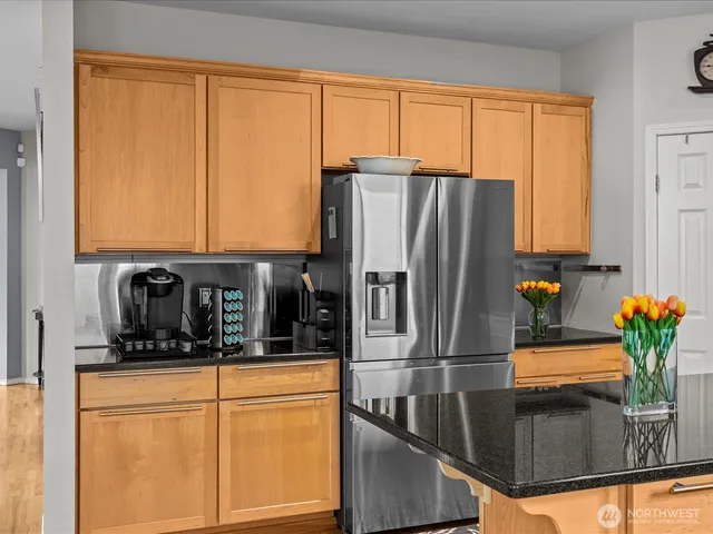 a kitchen with stainless steel appliances granite countertop a refrigerator and a sink