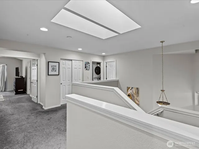 a large white kitchen with a large window and stainless steel appliances