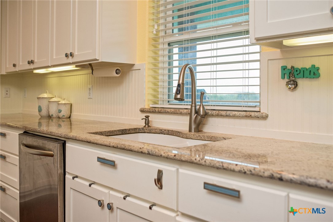 23 Macey Street Port O'Connor, TX 77982 - Photo 41 of 47 a kitchen with granite countertop a sink and a window