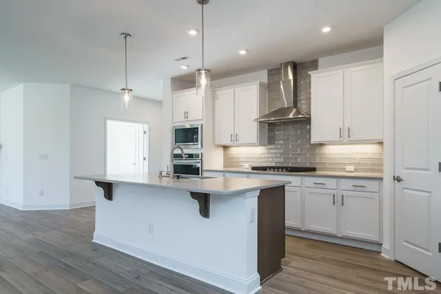 a kitchen with stainless steel appliances granite countertop a sink a stove and a refrigerator