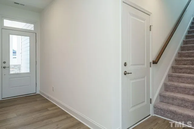 a view of a hallway with wooden floor and entryway