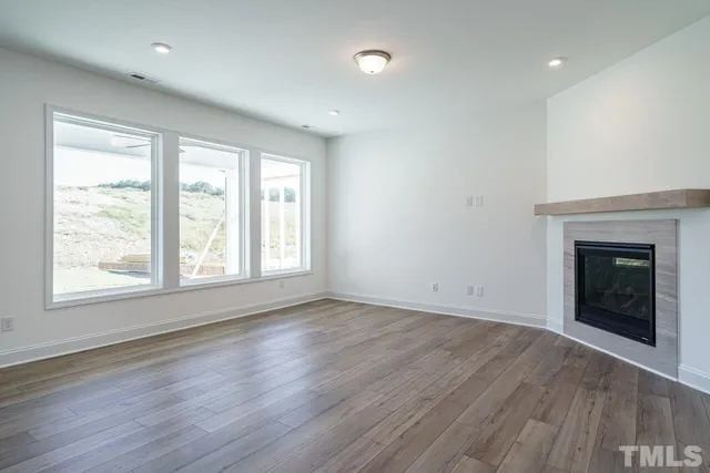 an empty room with wooden floor and a window
